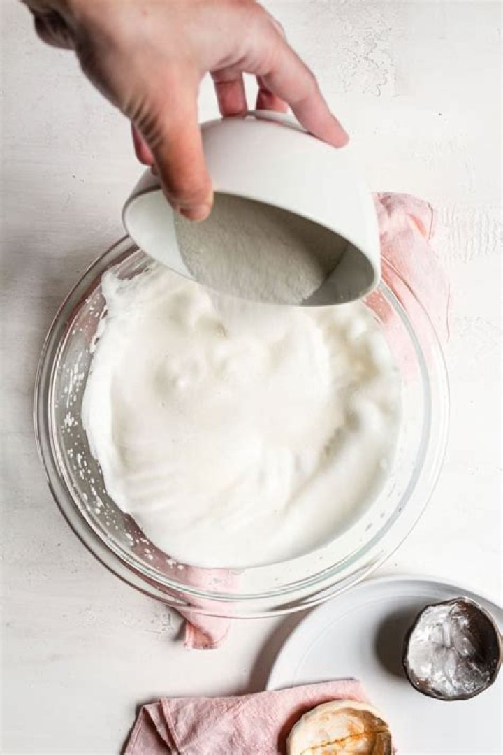 At what point do you add sugar to egg whites when making meringues?